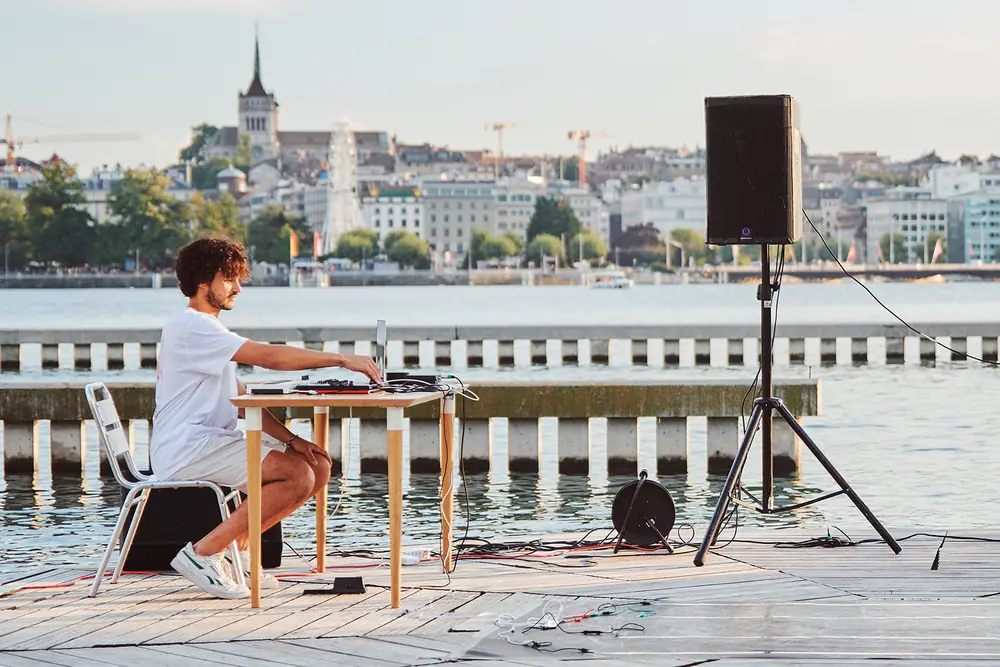 Naji au clavier lors d'une performance musicale en plein air, au bord du lac